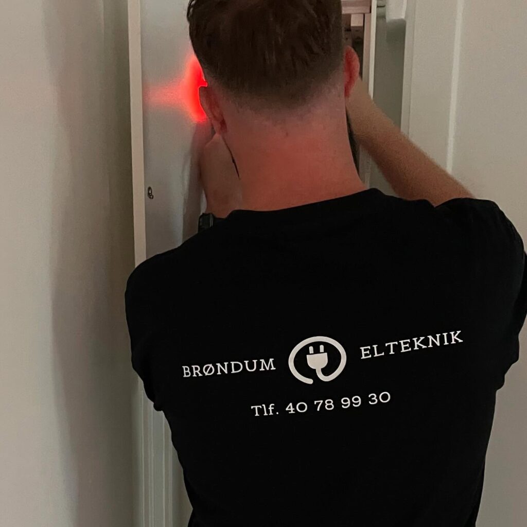 Elektriker arbejder med installation i væg